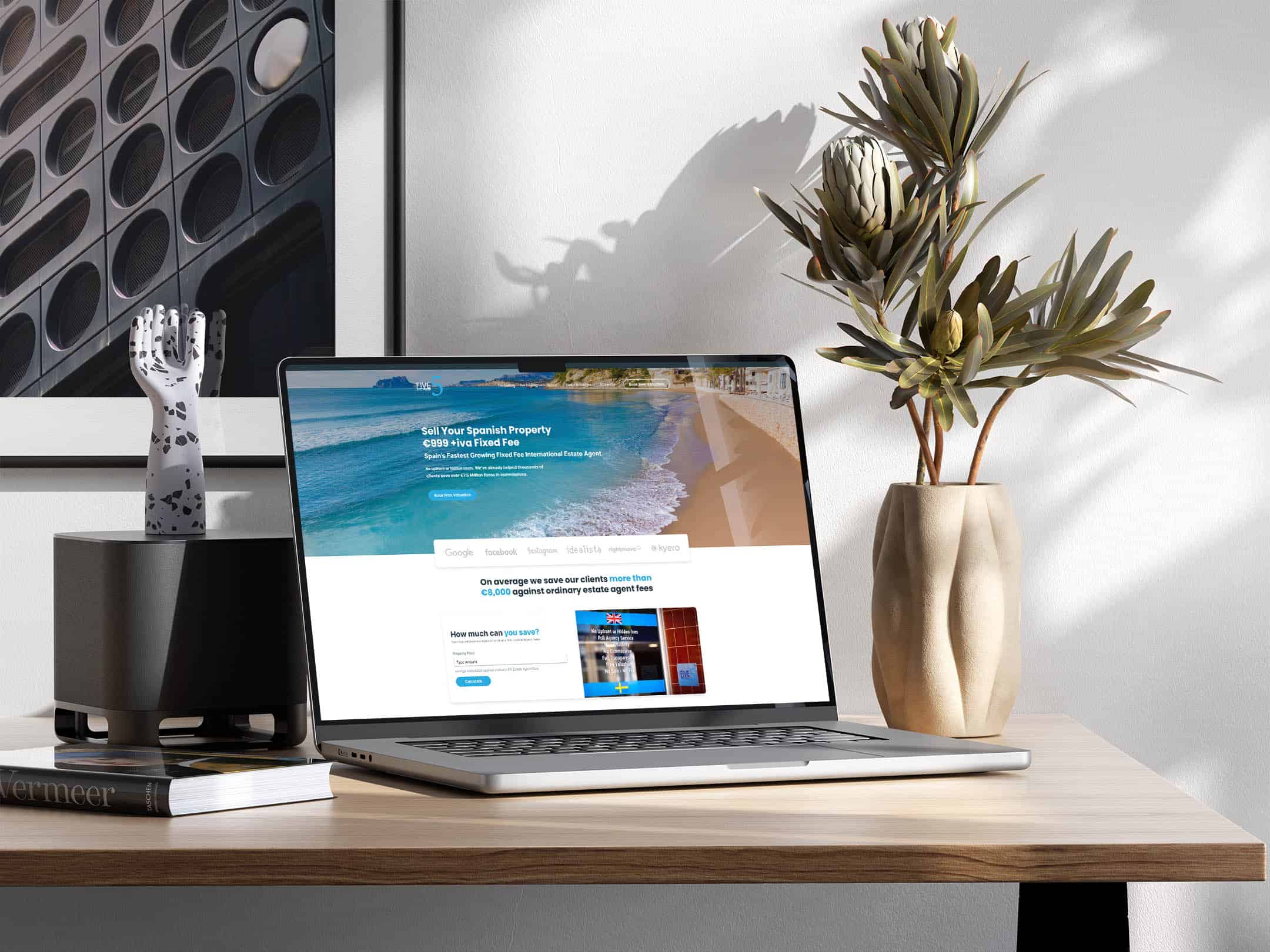 A laptop displaying the 5 Real Estate homepage