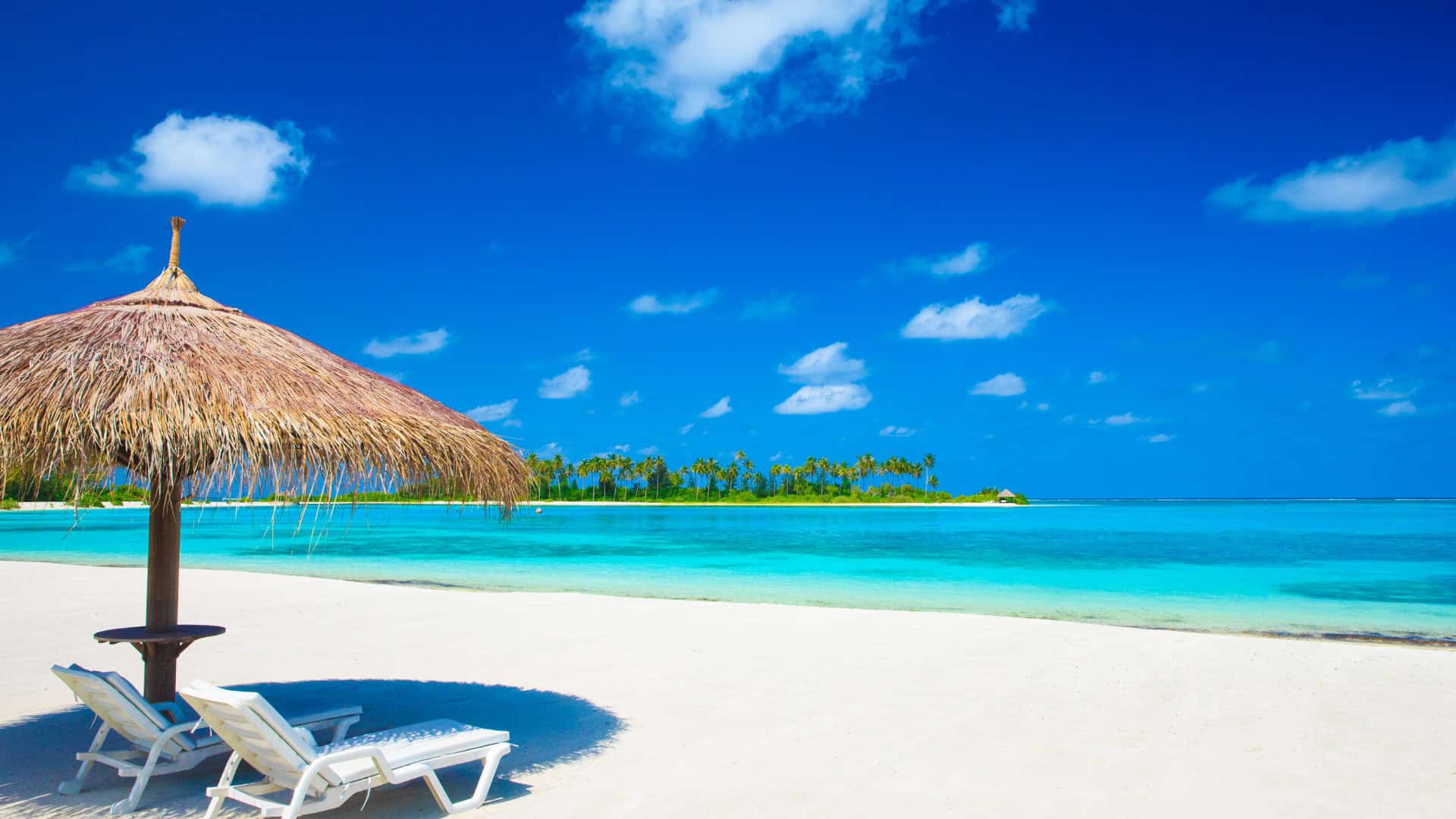 A pristinely white beach under a blue sky